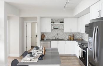 A modern kitchen with a dining table set for four.